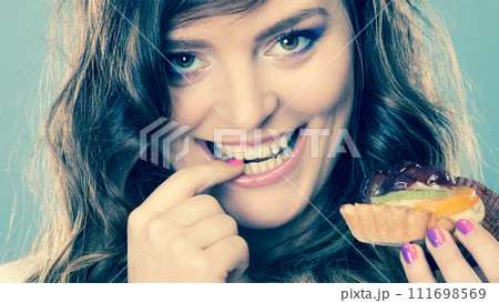 Smiling cute woman holds fruit cake in hand Smiling cute woman holds fruit cake in hand 111698569