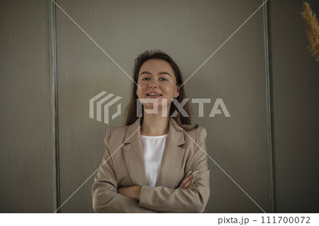 Happy Businesswoman in Office. Stylish Beautiful Manager Smiling It stands against green wall, Working on Financial and Marketing Projects Happy Businesswoman in Office. Stylish Beautiful Manager Smiling It stands against green wall, Working on Financial and Marketing Projects 111700072