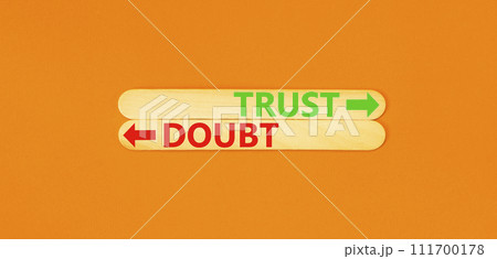 Trust or doubt symbol. Concept word Trust or Doubt on beautiful wooden stick. Beautiful orange table orange background. Business and trust or doubt concept. Copy space. Trust or doubt symbol. Concept word Trust or Doubt on beautiful wooden stick. Beautiful orange table orange background. Business and trust or doubt concept. Copy space. 111700178