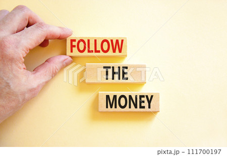 Follow the money symbol. Concept words Follow the money on beautiful wooden blocks. Beautiful white table white background. Businessman hand. Business and follow the money concept. Copy space. Follow the money symbol. Concept words Follow the money on beautiful wooden blocks. Beautiful white table white background. Businessman hand. Business and follow the money concept. Copy space. 111700197