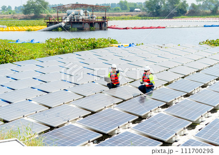 Wide shot of one professional technician worker point to the right and discuss with co-worker to work with solar cell panel system. 111700298
