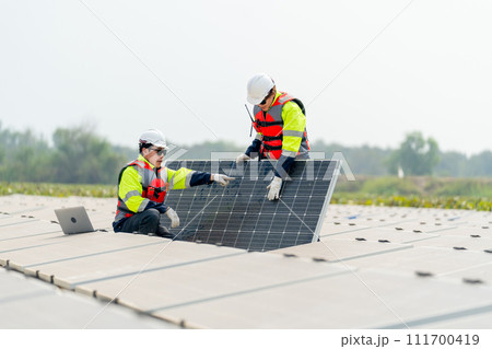 One technician worker sit and point to area of problem and work with co-worker who stand and touch to check the problem of solar cell panel in the network system. 111700419