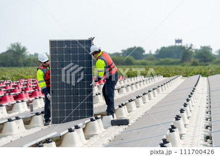 Front view of professional technician workers stand and hold solar cell panel to check and maintenance in concept of green energy for power plant. 111700426