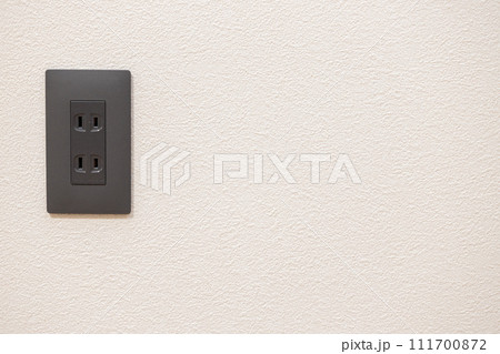 壁に設置されたコンセント（黒） 111700872