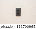 壁に設置されたコンセント（黒） 111700965