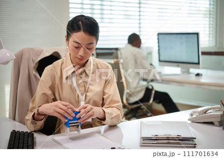 Bank manager sealing document, approving mortgage loan for client 111701634