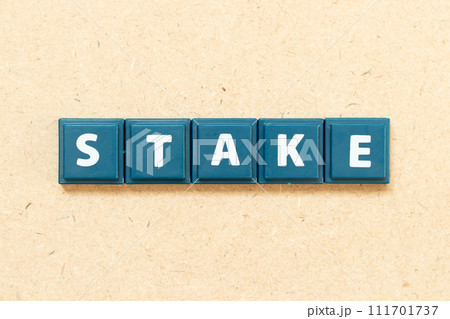 Tile alphabet letter in word stake on wood background Tile alphabet letter in word stake on wood background 111701737