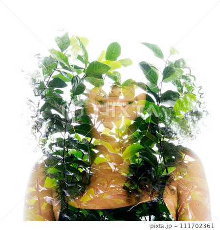 A double exposure portrait of a smiling woman merged with green leaves 111702361