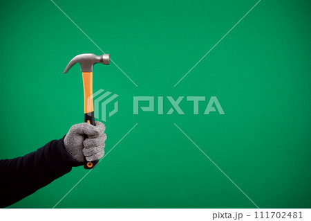 man's hand holding a hammer on a plain background. High quality photo man's hand holding a hammer on a plain background. High quality photo 111702481