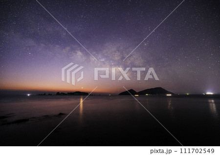 《宮崎県 猪崎鼻公園キャンプ場》七つ岩(ななつばえ)と大島と夜明けの天の川 111702549