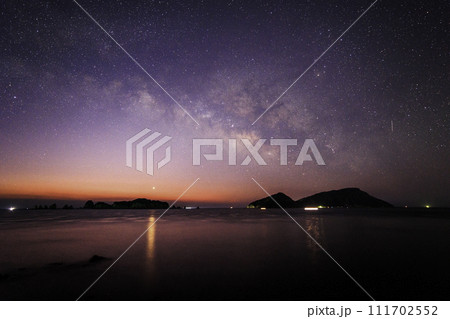 《宮崎県 猪崎鼻公園キャンプ場》七つ岩(ななつばえ)と大島と夜明けの天の川 111702552