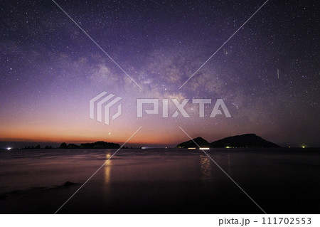 《宮崎県 猪崎鼻公園キャンプ場》七つ岩(ななつばえ)と大島と夜明けの天の川 111702553