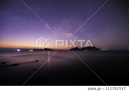 《宮崎県 猪崎鼻公園キャンプ場》七つ岩(ななつばえ)と大島と夜明けの天の川 111702557