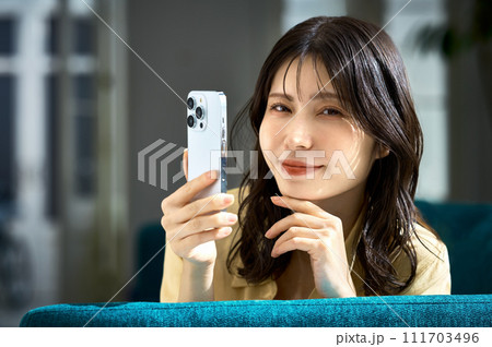 寝転んでスマホを見る女性 寝転んでスマホを見る女性 111703496