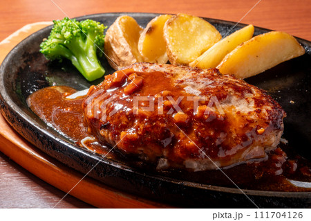 鉄板に盛り付けられたハンバーグ 111704126