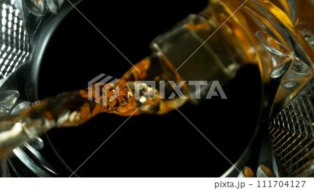 Freeze Motion Shot of Whiskey Liquid Pouring, Macro, Unique Angle of View from the Bottom of the Glass 111704127
