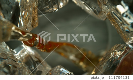 Freeze Motion Shot of Whiskey Liquid Pouring, Macro, Unique Angle of View from the Bottom of the Glass 111704131