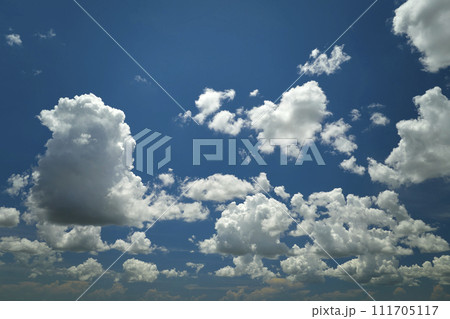 White puffy cumulus clouds on summer blue sky 111705117