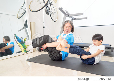 並んでストレッチをする男の子と大人の男性 並んでストレッチをする男の子と大人の男性 111705148