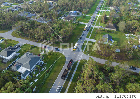 Top view of classical american yellow school bus picking up kids at rural town street stop for their lessongs in early morning. Public transport in the USA 111705180