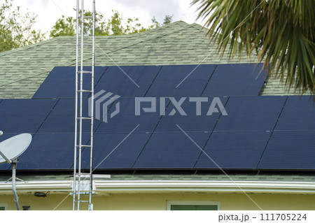 Standard american residential house with rooftop covered with solar photovoltaic panels for producing of clean ecological electrical energy in suburban rural area. Concept of autonomous home Standard american residential house with rooftop covered with solar photovoltaic panels for producing of clean ecological electrical energy in suburban rural area. Concept of autonomous home 111705224