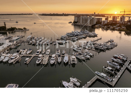 Sarasota Bay marina with luxury yachts and Florida city architecture at sunset. High-rise office buildings in downtown district. Real estate development in Florida. USA travel destination Sarasota Bay marina with luxury yachts and Florida city architecture at sunset. High-rise office buildings in downtown district. Real estate development in Florida. USA travel destination 111705250