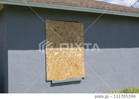 Plywood storm shutters for hurricane protection of house windows. Protective measures before natural disaster in Florida 111705299