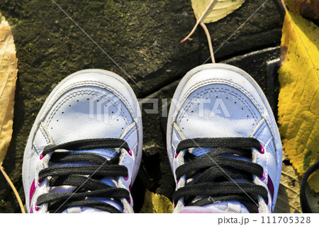 Pair of child white shoes on nature background Pair of child white shoes on nature background 111705328