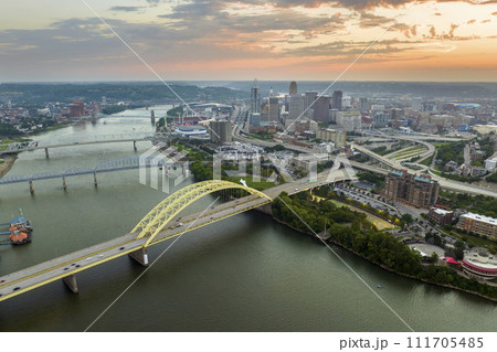 Highway traffic in Cincinnati, Ohio on Daniel Carter Beard Bridge with brightly illuminated high skyscraper buildings in downtown district. American city with business financial district at sunset 111705485