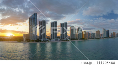 High angle view of Sunny Isles Beach city at sunset with expensive highrise hotels and condo buildings over beachfront on Atlantic shore. American tourism infrastructure in coastal southern Florida 111705488