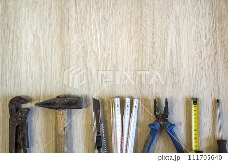Construction, building and repair tools set for house work on wooden background. Top view. Construction, building and repair tools set for house work on wooden background. Top view. 111705640