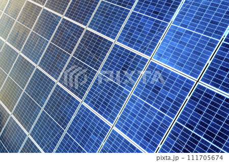 Close-up surface of lit by sun blue shiny solar photo voltaic panels. System producing renewable clean energy. Renewable ecological green energy production concept. 111705674