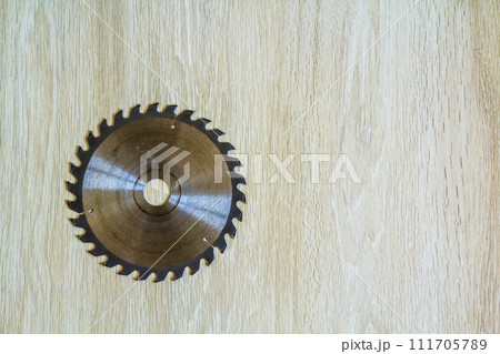 Close up of circular saw blade for wood work on wooden background. Top view. Close up of circular saw blade for wood work on wooden background. Top view. 111705789
