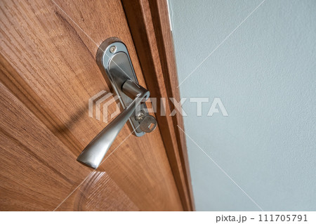 Close up of a metal door handle on wooden doors. Close up of a metal door handle on wooden doors. 111705791