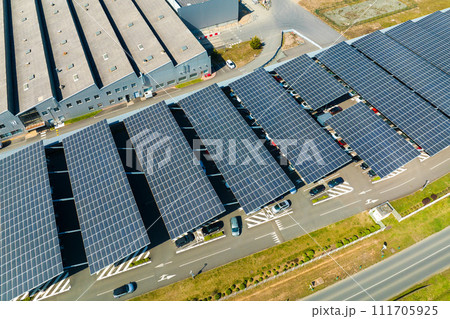 Aerial view of solar panels installed over parking lot with parked cars for effective generation of clean energy Aerial view of solar panels installed over parking lot with parked cars for effective generation of clean energy 111705925