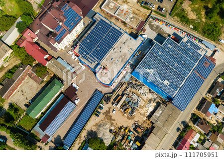 Aerial view of many photo voltaic solar panels mounted of industrial building roof. 111705951