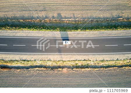 Aerial view of intercity road with blurred fast driving car at sunset. Top view from drone of highway traffic in evening 111705969