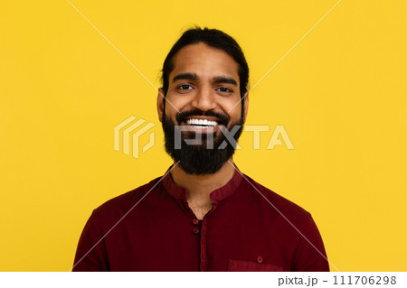 Portrait of smiling handsome young indian man posing on yellow Portrait of smiling handsome young indian man posing on yellow 111706298