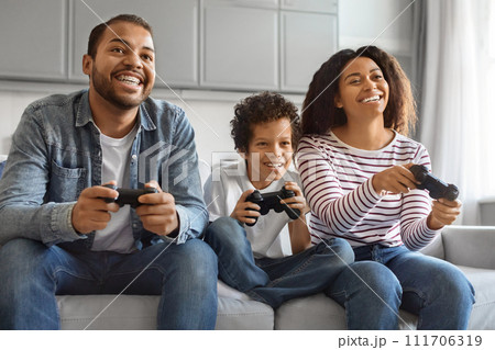 Happy Black Preteen Boy Playing Video Games With His Parents At Home Happy Black Preteen Boy Playing Video Games With His Parents At Home 111706319
