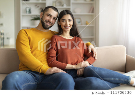 Happy Romantic Young Couple Hugging While Posing On Couch At Home Interior Happy Romantic Young Couple Hugging While Posing On Couch At Home Interior 111706530