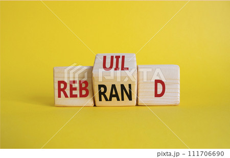 Rebuild and Rebrand symbol. Wooden cubes with words Rebrand and Rebuild. Beautiful yellow background. Rebuild Rebrand and Business concept. Copy space 111706690