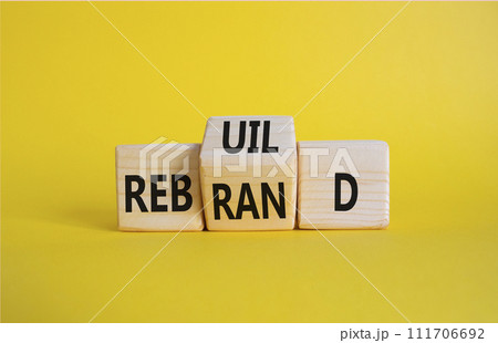 Rebuild and Rebrand symbol. Wooden cubes with words Rebrand and Rebuild. Beautiful yellow background. Rebuild Rebrand and Business concept. Copy space 111706692