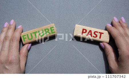 Future or Past symbol. Concept word Future or Past on wooden blocks. Businessman hand. Beautiful grey background. Business and Future or Past concept. Copy space 111707342