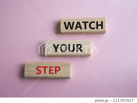 Watch your Step symbol. Concept words Watch your Step on wooden blocks. Beautiful pink background. Business and Watch your Step concept. Copy space. 111707427