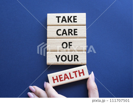 Health symbol. Wooden blocks with words Take Care of your Health. Doctor hand. Beautiful deep blue background. Health concept. Copy space. 111707501