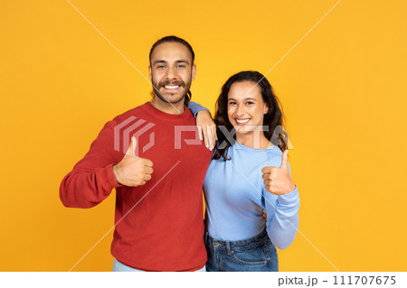 Happy millennial couple hugging and showing thumb up 111707675