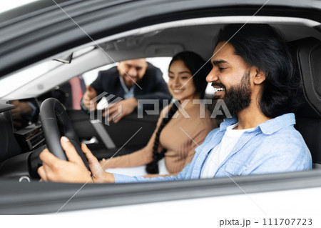Excited young indian couple sitting inside brand new car Excited young indian couple sitting inside brand new car 111707723
