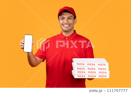 deliveryman showcases smartphone screen holding pizza boxes on yellow background 111707777