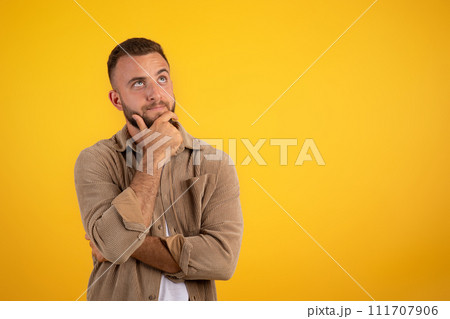 Focused pensive young caucasian man with beard in casual thinks Focused pensive young caucasian man with beard in casual thinks 111707906