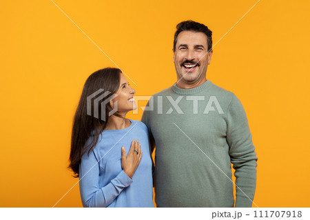 A joyful woman and man, dressed in casual clothing, laugh together A joyful woman and man, dressed in casual clothing, laugh together 111707918